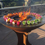 Skewers with colorful vegetables over a fire pit on a patio
